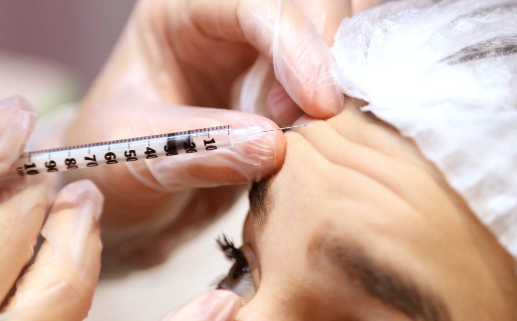 What Age Is Best To Get Botox®? 1 Woman receiving Botox injections in a clinic to reduce fine lines and wrinkles.