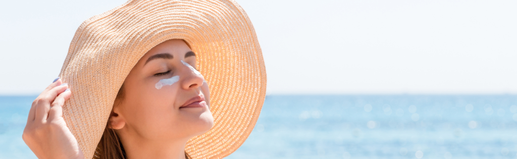 women with a hat and sunscreen on her face