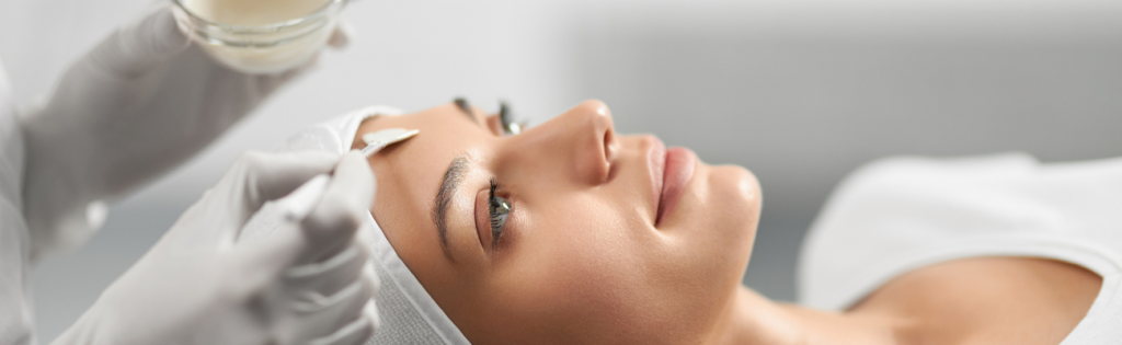 Woman receiving a relaxing facial treatment with a skincare face mask.