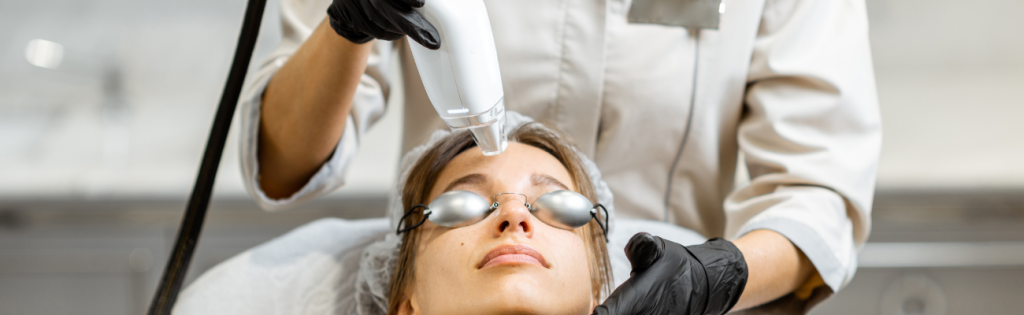 an aesthetic practitioner using laser machine on a client
