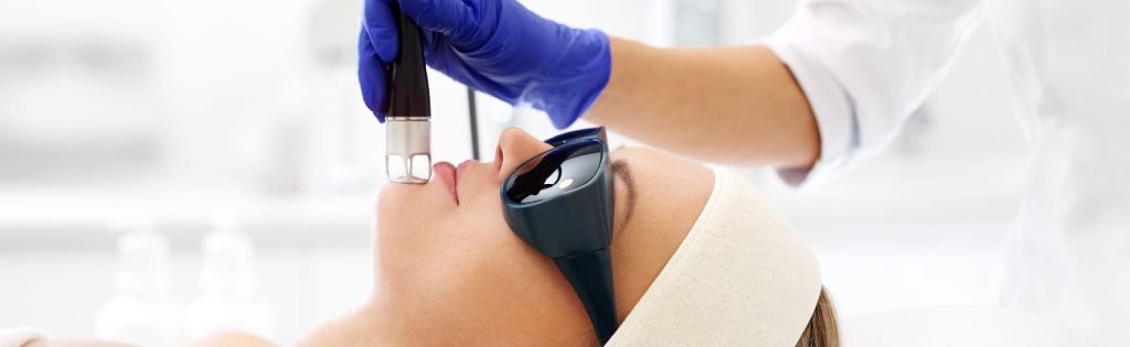 Client receiving laser treatment in a professional aesthetic clinic for skin rejuvenation or hair removal.