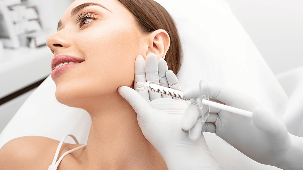 Demystifying Aesthetic Treatments: Dispelling Common Myths and Misconceptions 1 Woman receiving jawline filler treatment in a clinic to enhance facial definition and contour.
