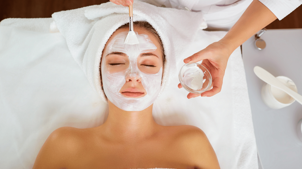 Client relaxing while receiving a professional face mask treatment at a spa.