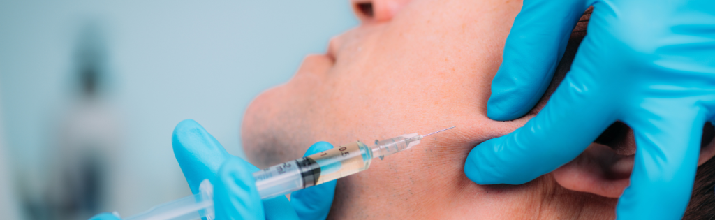 Male client receiving jawline filler treatment for enhanced facial definition.