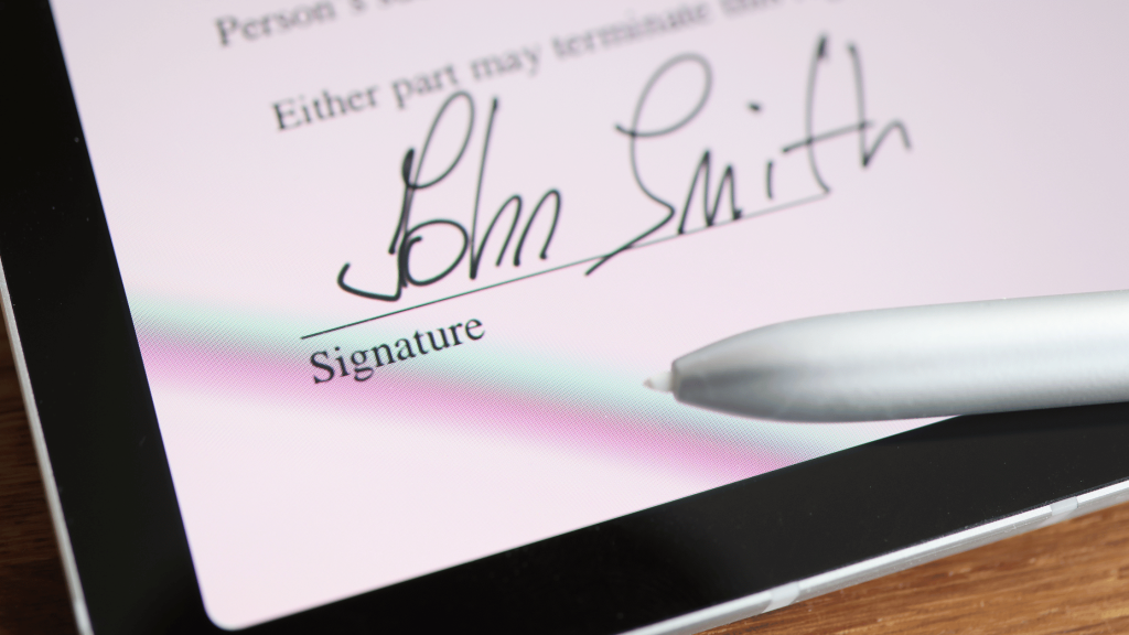 Faces | The Critical Role of Consent Forms in the Aesthetic Industry 1 Client signing a digital consent form on a tablet in a professional clinic setting.