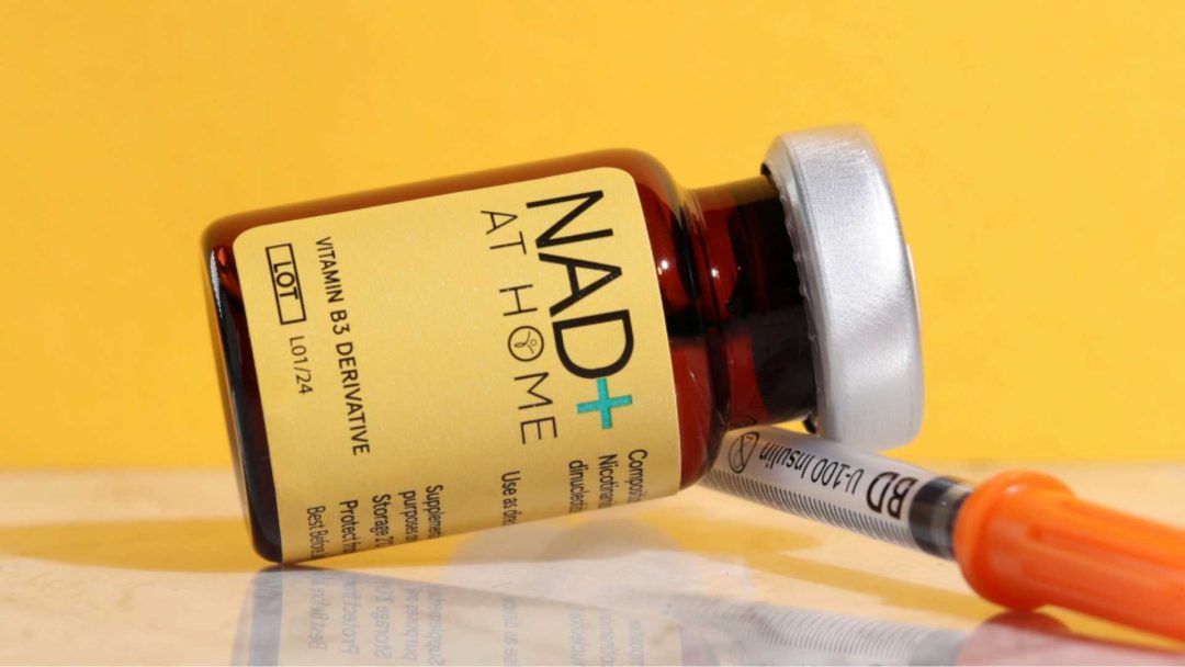 NAD+: A Game-Changer in the Aesthetics Industry (2024)? 1 NAD+ with syringe tumbled down on the right side with yellow background
